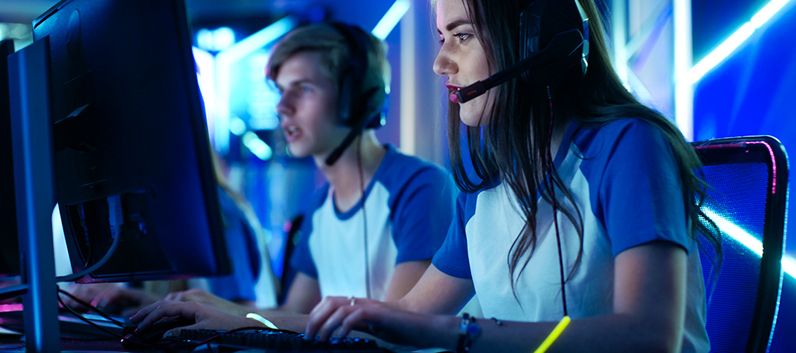 girl and boy side by side playing PC videogames